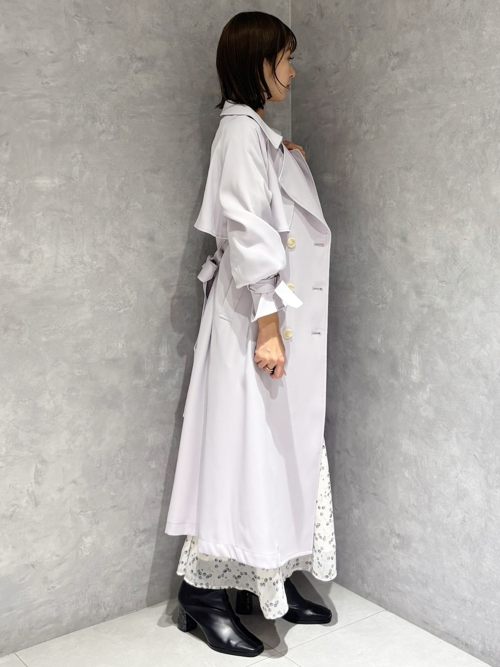 ホワイト系のワンピース、ブラック系のブーツ、パープル系のトレンチコートを着用したレディースの冬コーディネートの2枚目の写真