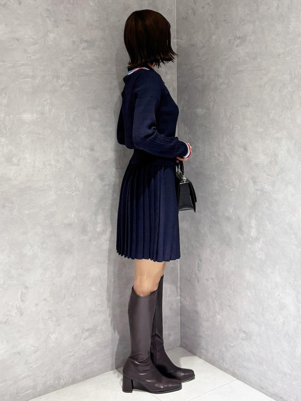 ブルー系のワンピース、ブラック系のハンドバッグ、ブラウン系のブーツを着用したレディースの冬コーディネートの3枚目の写真