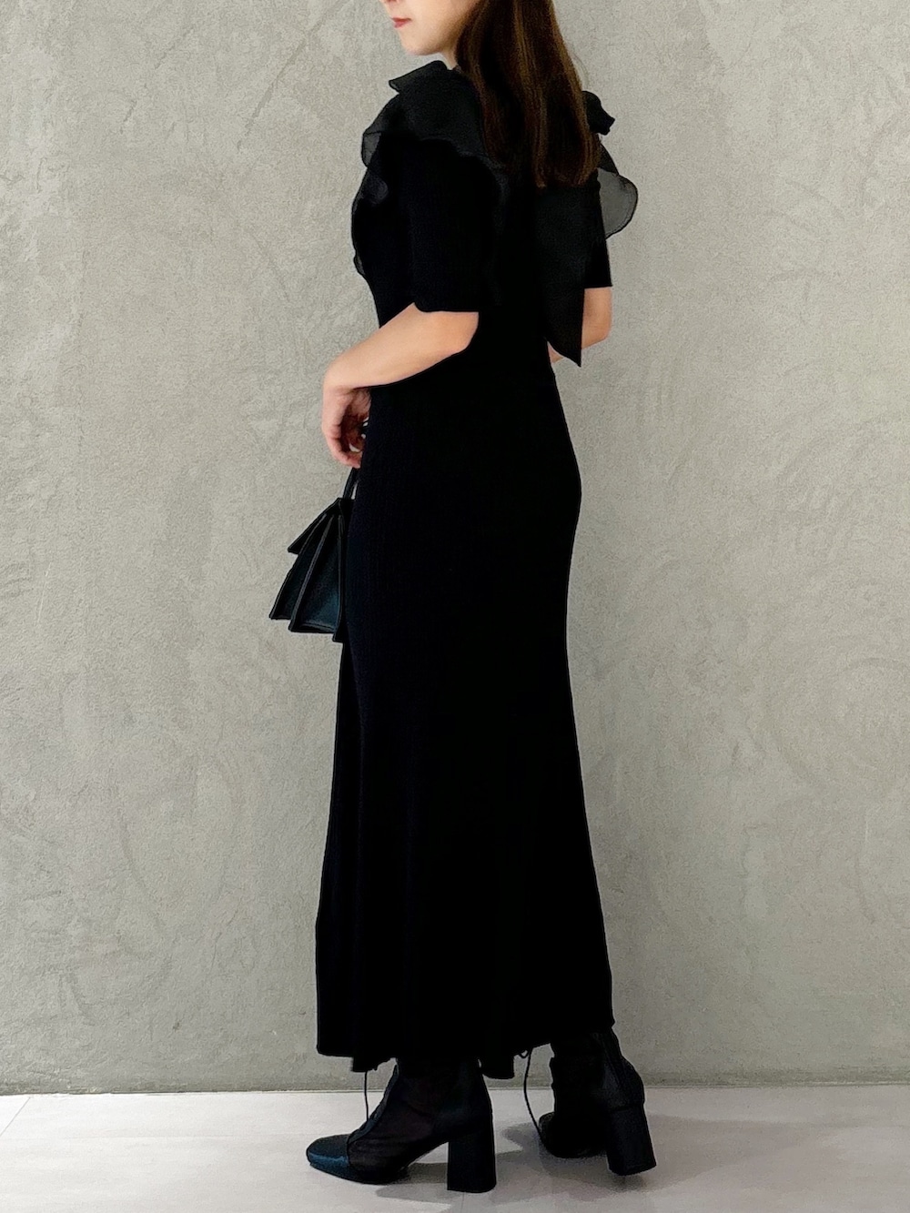 ブラック系のワンピース、ブラック系のショルダーバッグ、ブラック系のブーツを着用したレディースの夏コーディネートの2枚目の写真