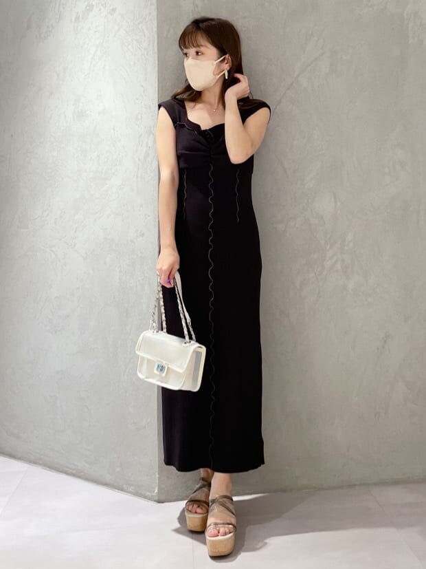 ブラック系のワンピース、ホワイト系のショルダーバッグ、グリーン系のサンダルを着用したレディースの春コーディネートの7枚目の写真