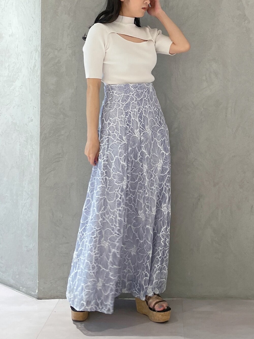 ブルー系のスカート、ブラック系のサンダル、ホワイト系のニット/セーターを着用したレディースの春コーディネートの2枚目の写真