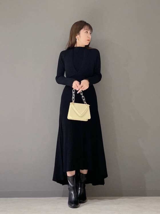 ブラック系のワンピース、ブラック系のその他シューズ、イエロー系のショルダーバッグを着用したレディースの冬コーディネートの7枚目の写真