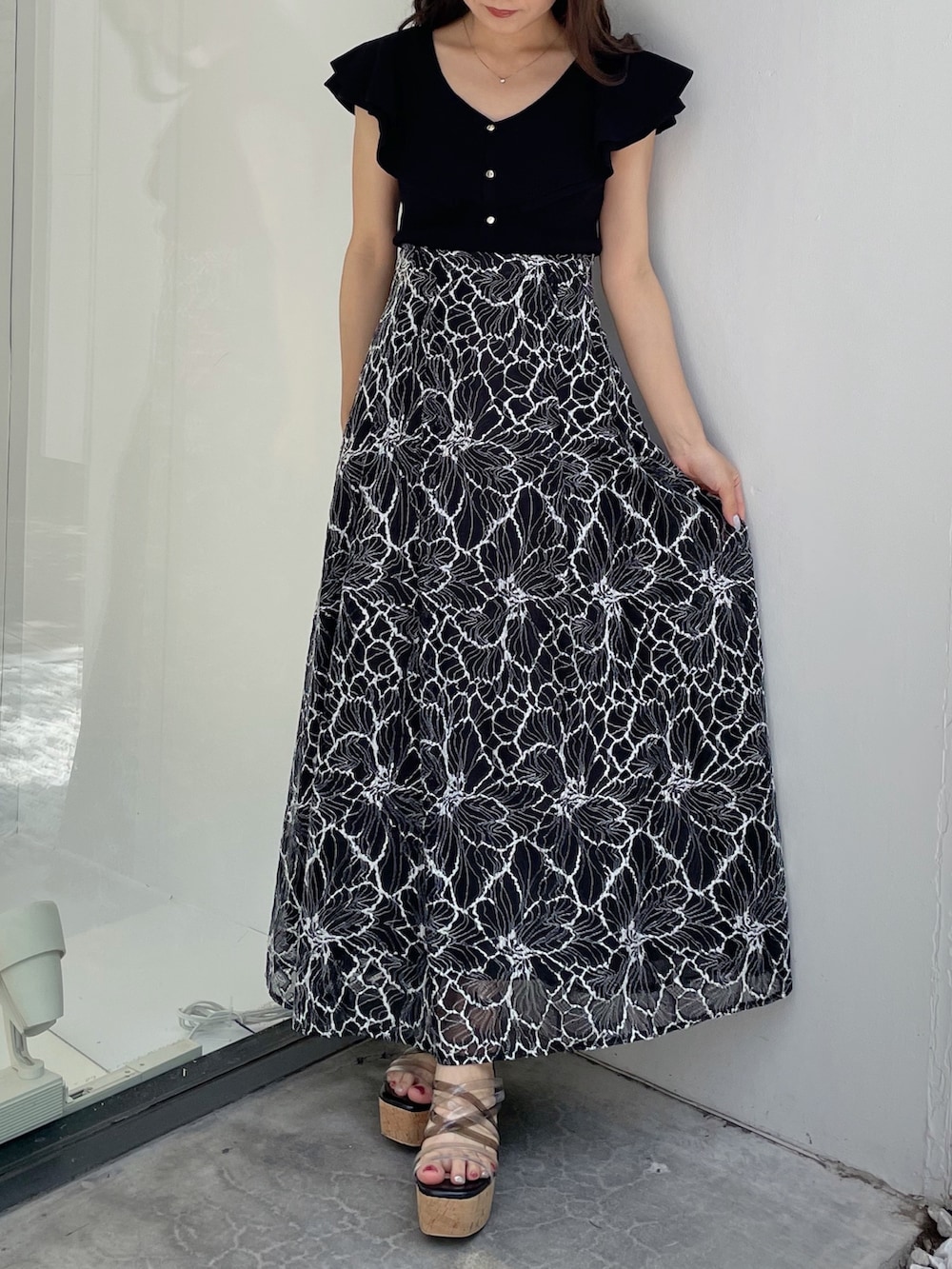 ブラック系のスカート、ブラック系のサンダル、ブラック系のニット/セーターを着用したレディースの夏コーディネートの6枚目の写真