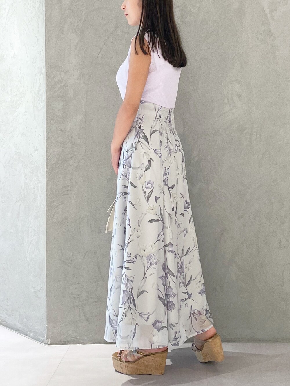 パープル系のワンピース、ブラウン系のサンダル、ベージュ系のショルダーバッグを着用したレディースの夏コーディネートの2枚目の写真