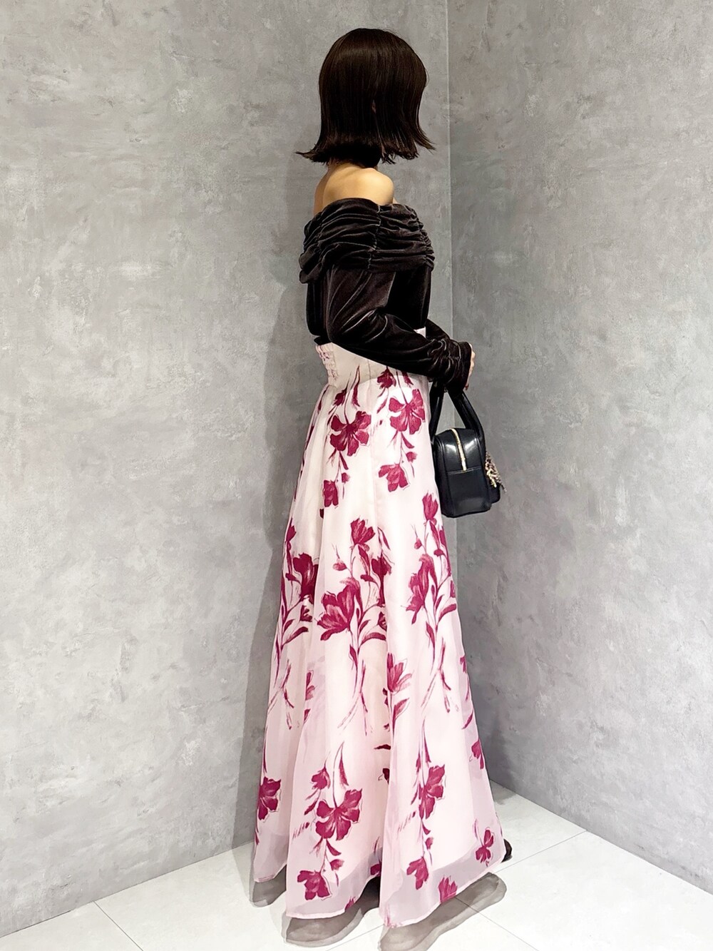 ブラック系のハンドバッグ、ブラウン系のTシャツ/カットソー、ピンク系のスカートを着用したレディースの秋コーディネートの4枚目の写真