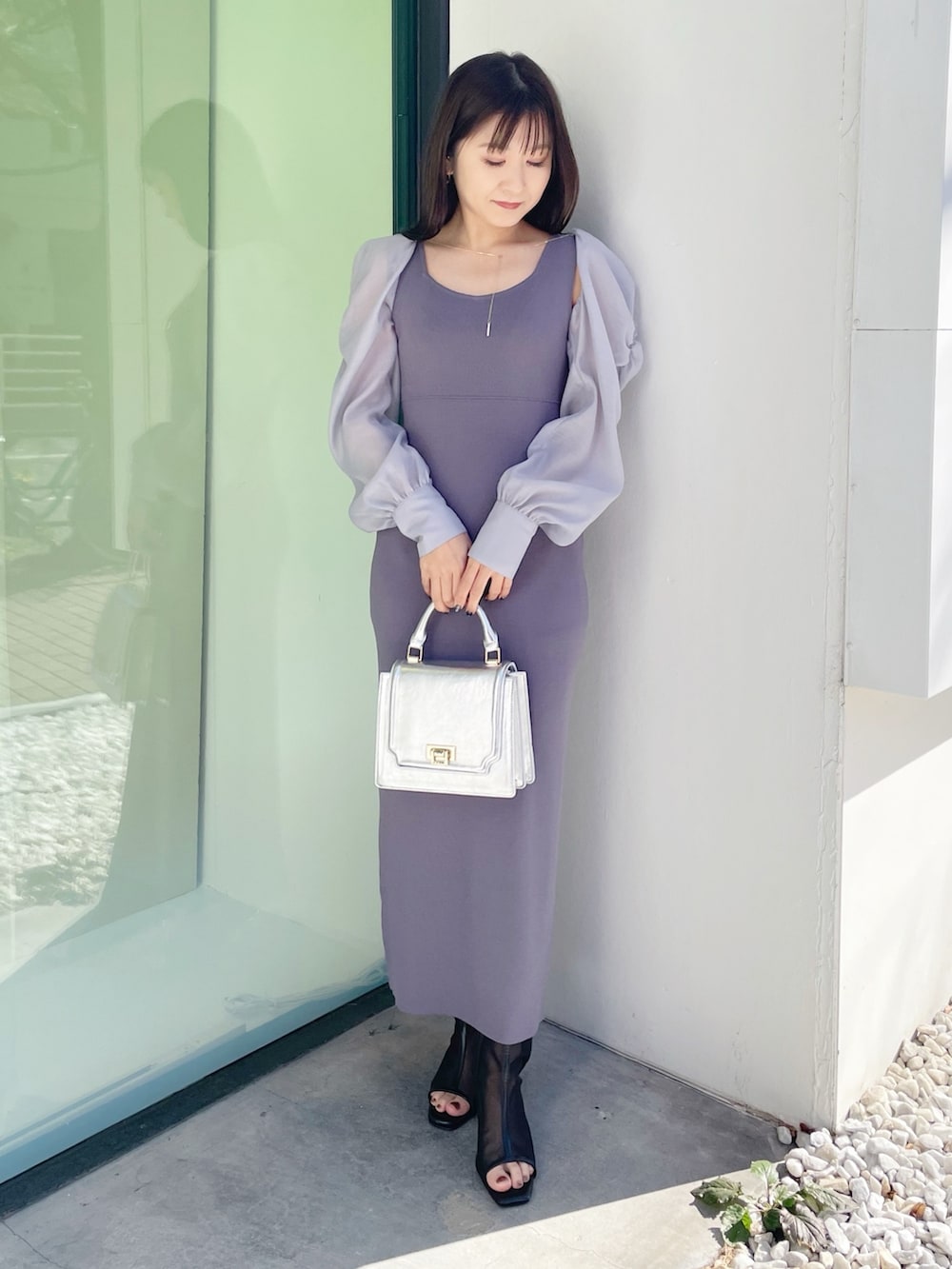 シルバー系のハンドバッグ、ブラック系のブーツ、ブルー系のワンピースを着用したレディースの春コーディネートの7枚目の写真