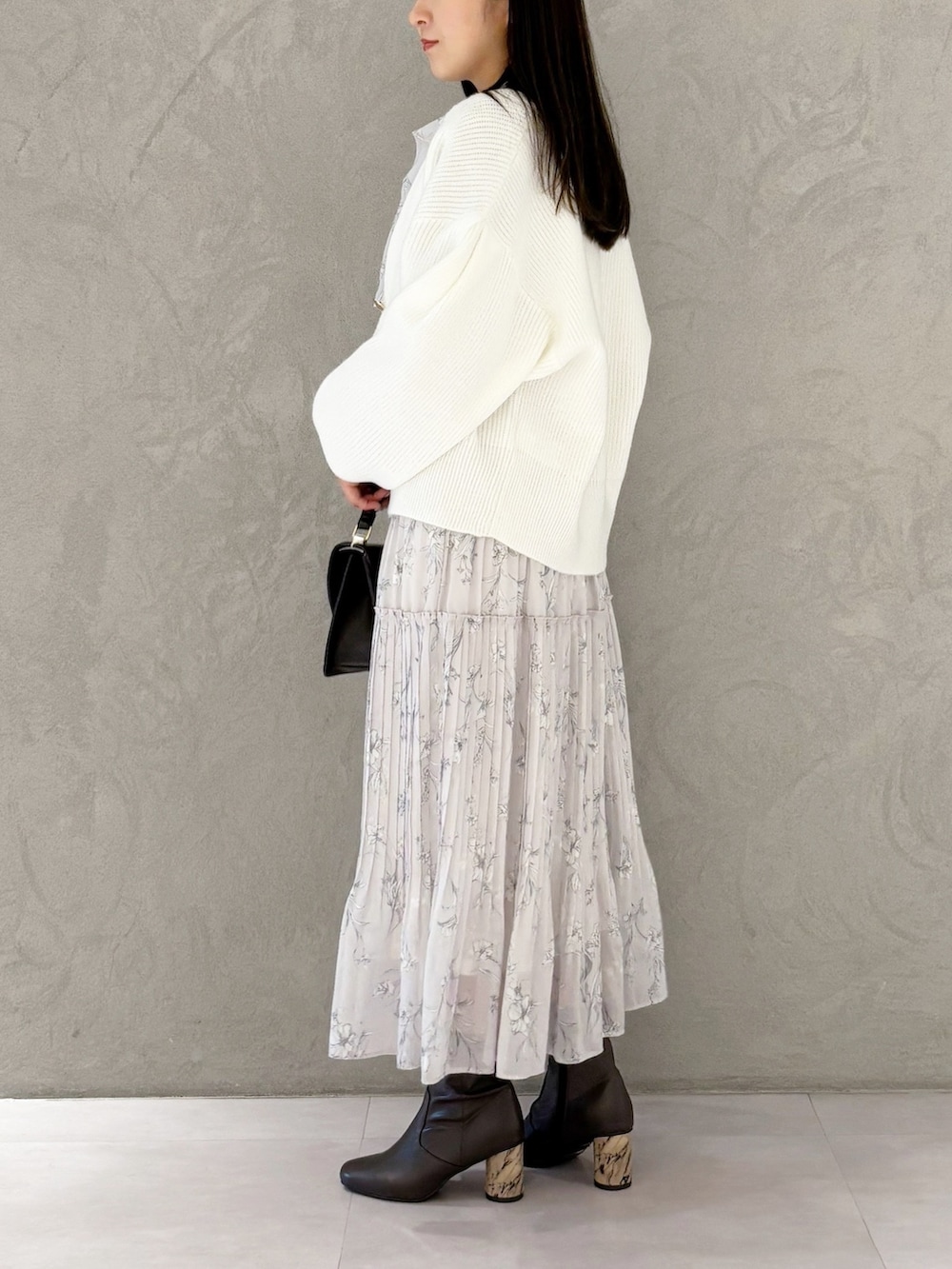 ピンク系のワンピース、ブラウン系のブーツ、ブラウン系のハンドバッグを着用したレディースの冬コーディネートの5枚目の写真