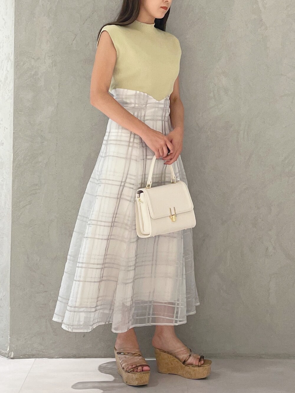 グリーン系のワンピース、ブラウン系のサンダル、ホワイト系のショルダーバッグを着用したレディースの夏コーディネートの2枚目の写真