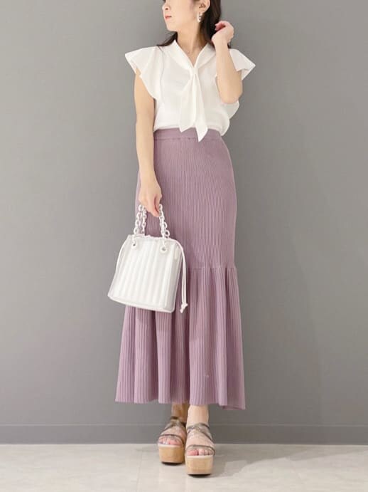 ホワイト系のハンドバッグ、ホワイト系のニット/セーター、グリーン系のサンダルを着用したレディースの春コーディネートの6枚目の写真