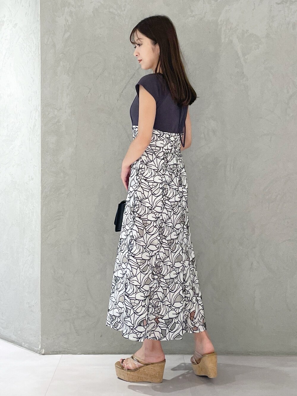 ブラック系のショルダーバッグ、ブラウン系のサンダル、ホワイト系のワンピースを着用したレディースの夏コーディネートの4枚目の写真