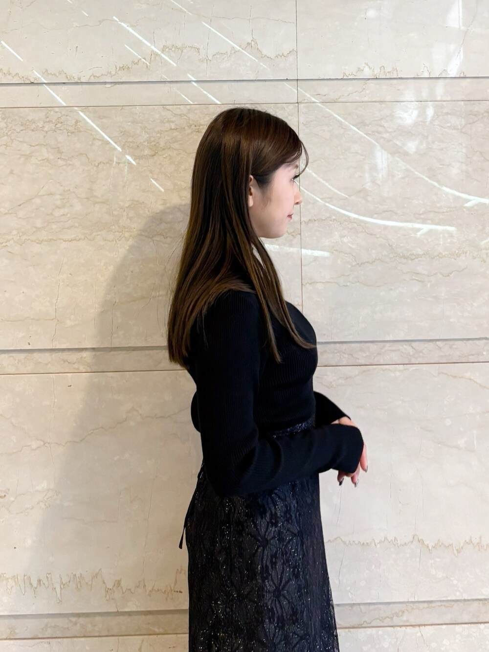 ブラック系のスカート、ブラック系のニット/セーター、ブラック系のブーツを着用したレディースの冬コーディネートの10枚目の写真