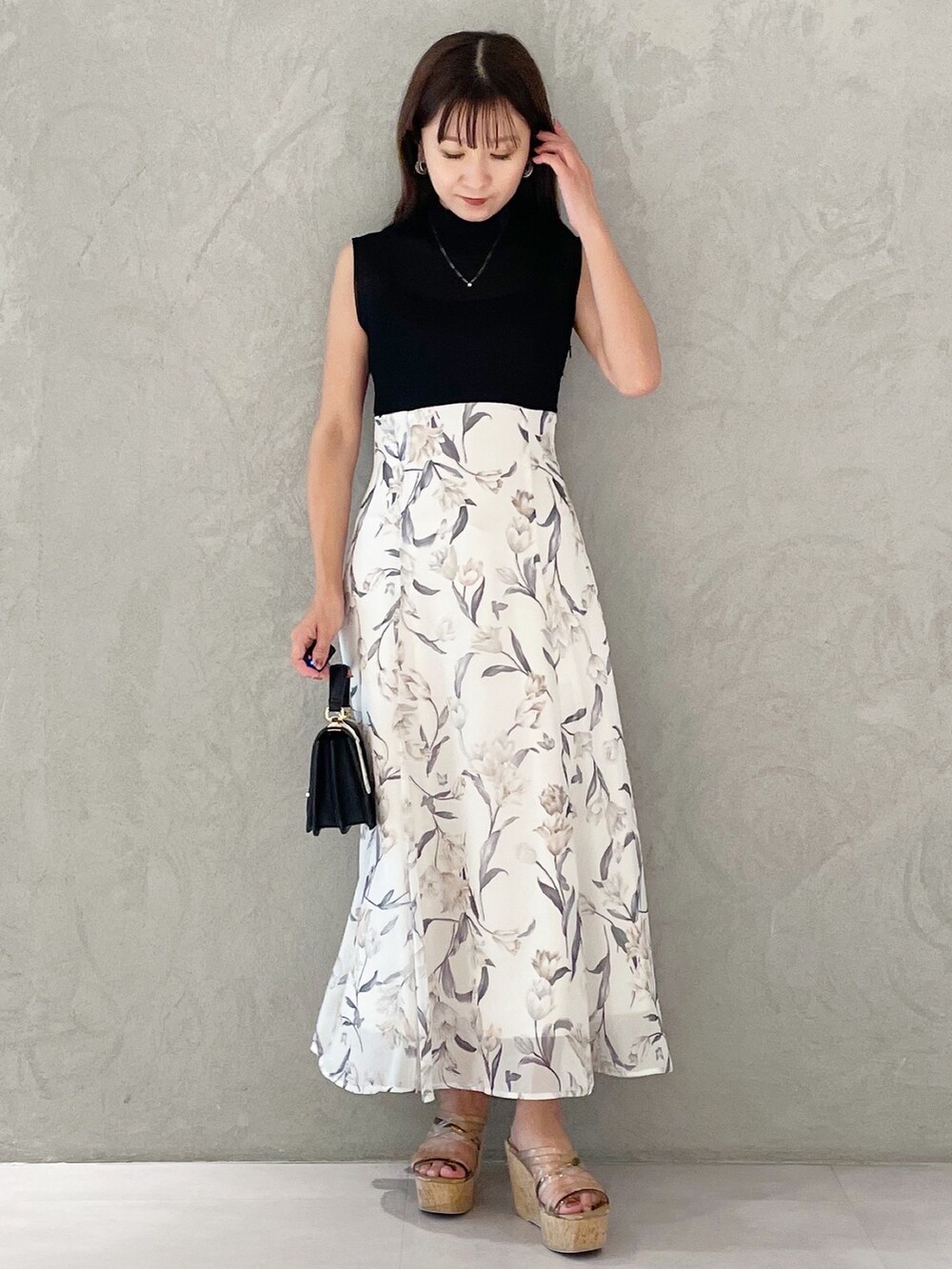 ブラック系のワンピース、ブラウン系のサンダル、ブラック系のハンドバッグを着用したレディースの夏コーディネートの6枚目の写真