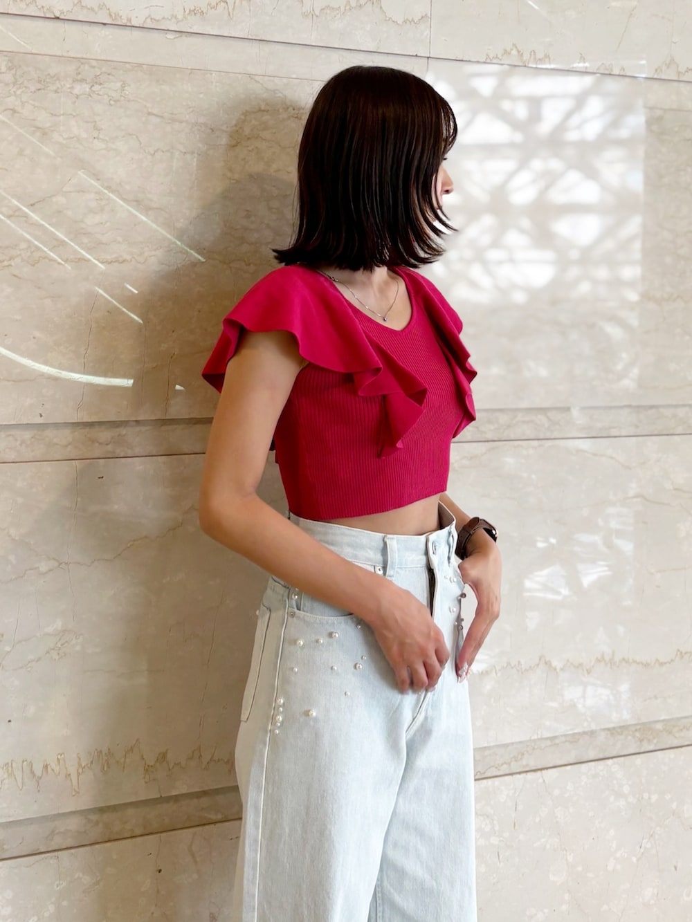 ブルー系のデニムパンツ、ホワイト系のサンダル、レッド系のニット/セーターを着用したレディースの夏コーディネートの4枚目の写真