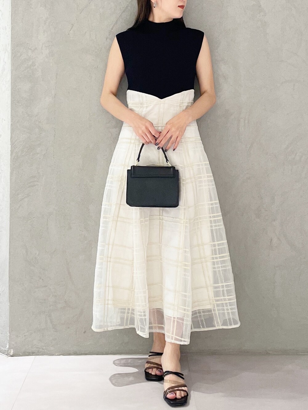 ブラック系のショルダーバッグ、ブラック系のサンダル、ブラック系のワンピースを着用したレディースの春コーディネートの5枚目の写真