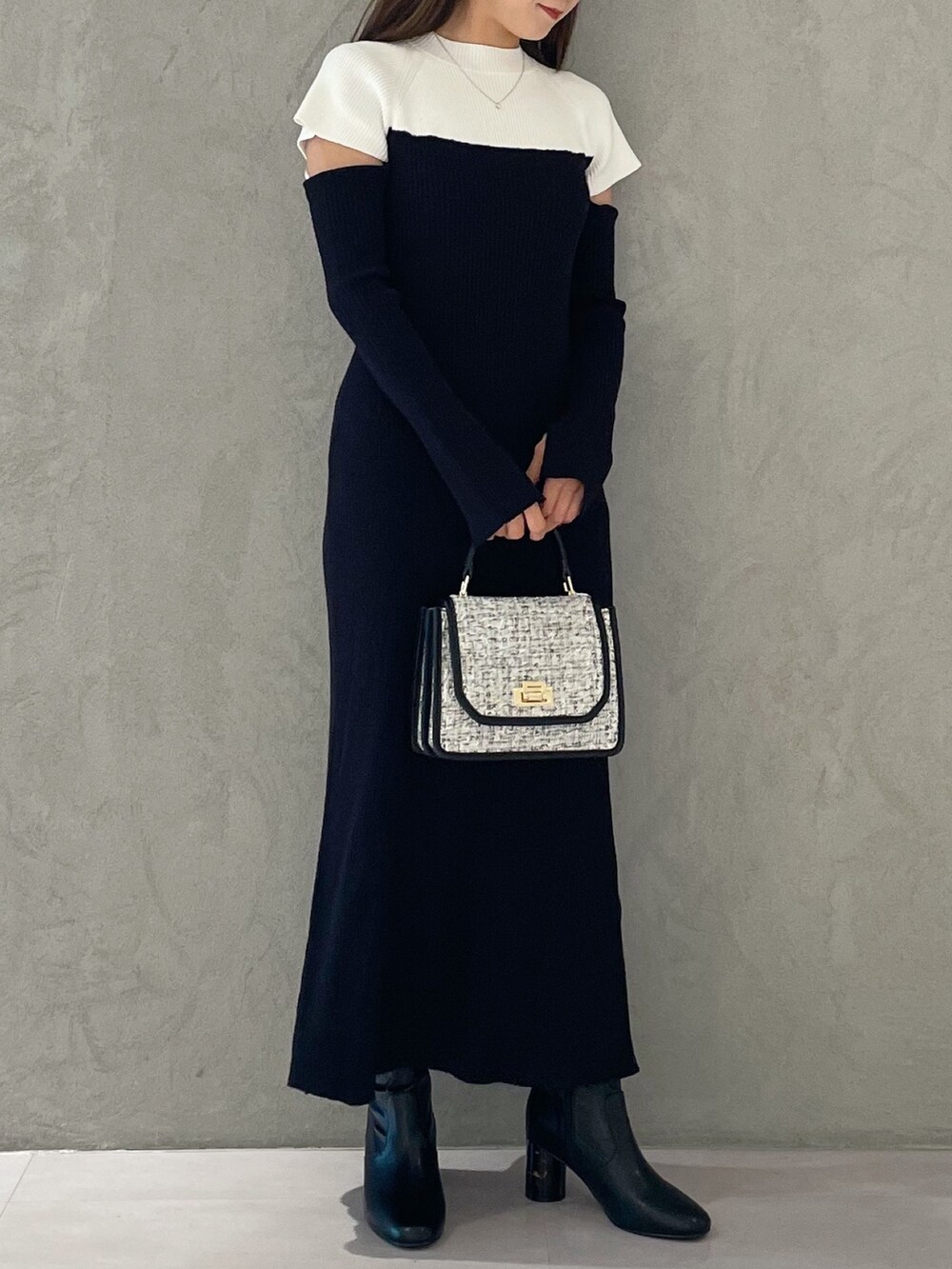 ブラック系のワンピース、ブラック系のショルダーバッグ、ブラック系のブーツを着用したレディースの秋コーディネートの3枚目の写真