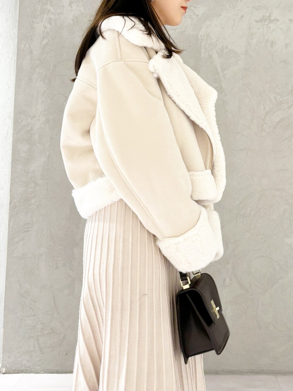 ホワイト系のワンピース、ブラック系のブーツ、ホワイト系のムートンコートを着用したレディースの秋コーディネートの2枚目の写真