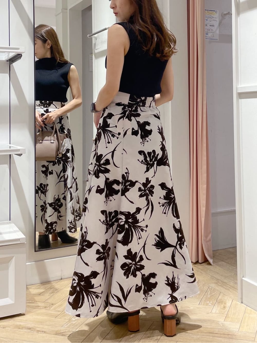 ホワイト系のスカート、ブラック系のサンダル、ブラック系のニット/セーターを着用したレディースの夏コーディネートの3枚目の写真