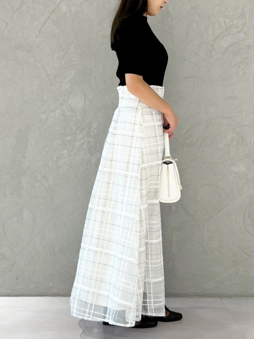 ホワイト系のスカート、ブラウン系のブーツ、ホワイト系のショルダーバッグを着用したレディースの秋コーディネートの4枚目の写真