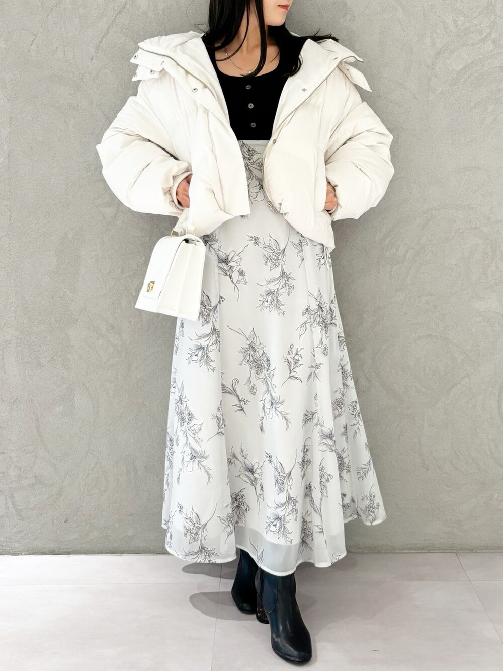 ブラック系のワンピース、ブラック系のブーツ、ホワイト系のハンドバッグを着用したレディースの秋コーディネートの8枚目の写真