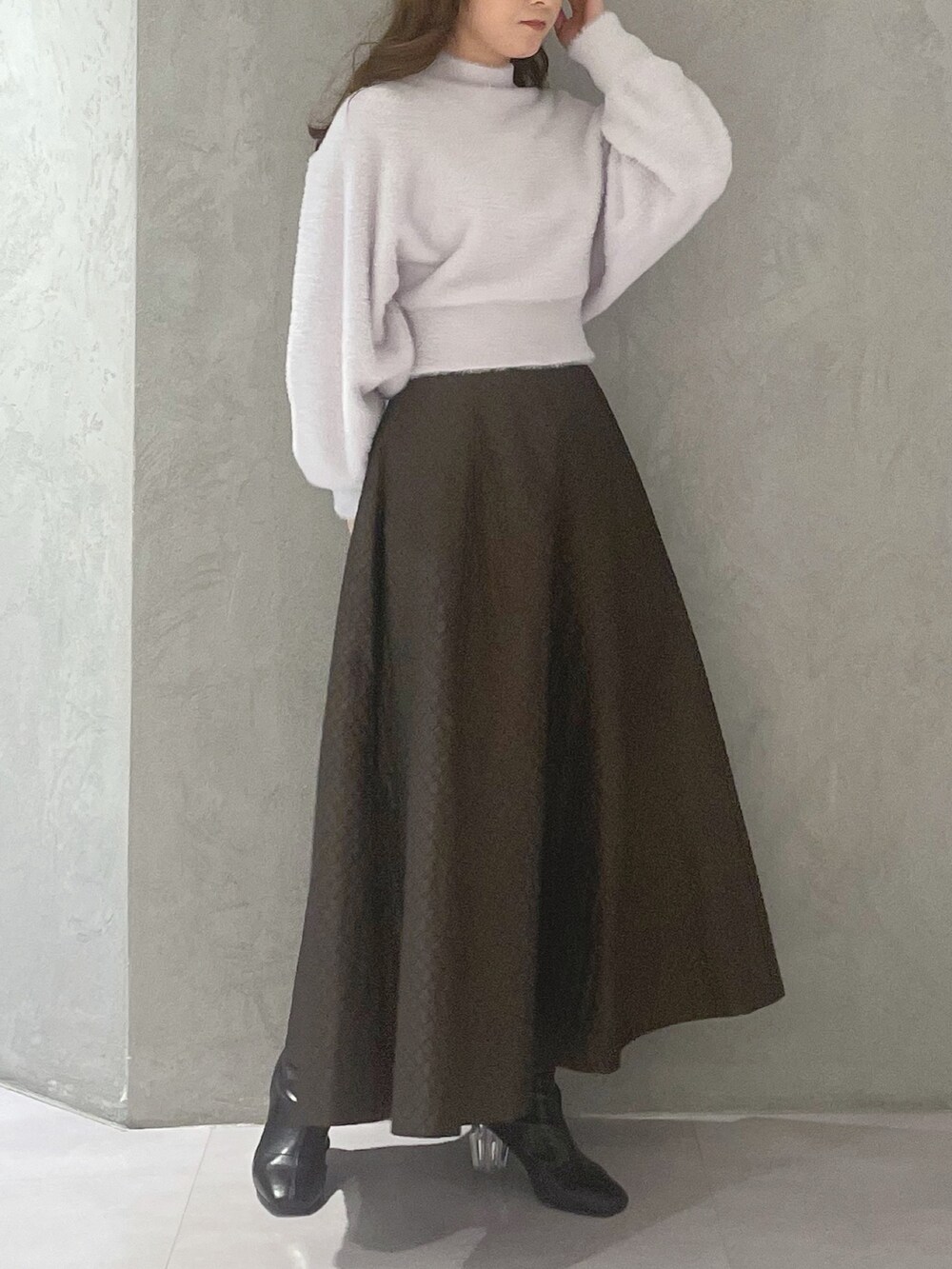 ブラウン系のスカート、パープル系のニット/セーターを着用したレディースの冬コーディネートの2枚目の写真