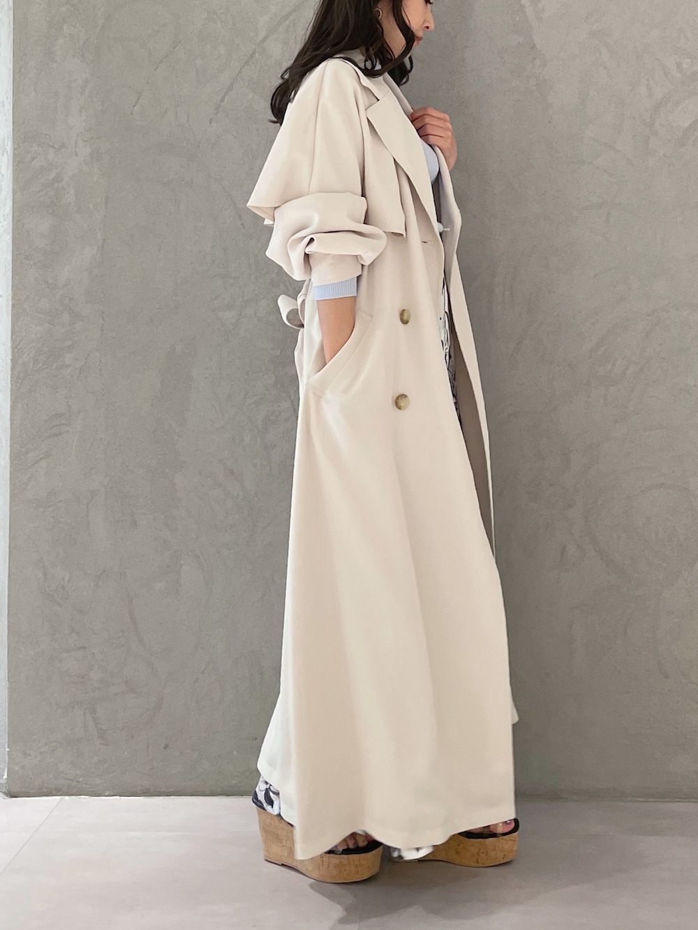 ホワイト系のスカート、ブルー系のニット/セーター、ホワイト系のトレンチコートを着用したレディースの春コーディネートの6枚目の写真