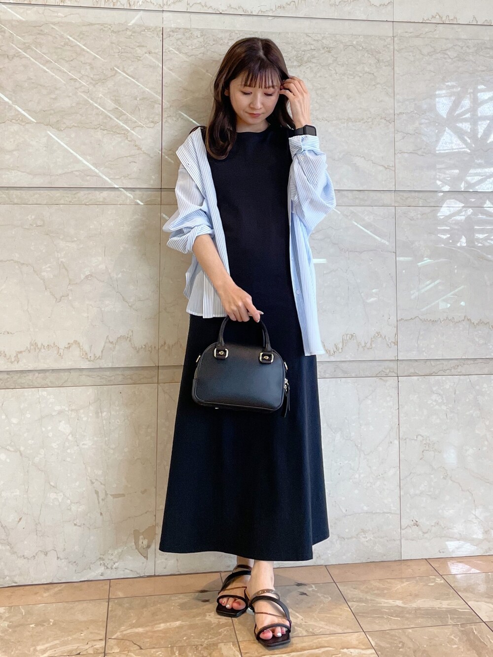 ホワイト系のボストンバッグ、ブラック系のサンダル、ブルー系のシャツ/ブラウスを着用したレディースの春コーディネートの8枚目の写真