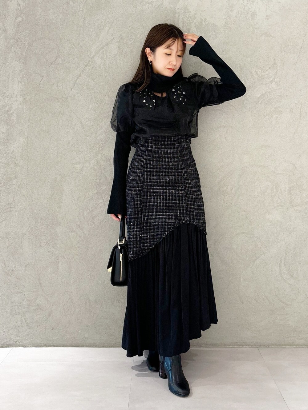 ブラック系のスカート、ブラック系のショルダーバッグ、ブラック系のブーツを着用したレディースの秋コーディネートの9枚目の写真