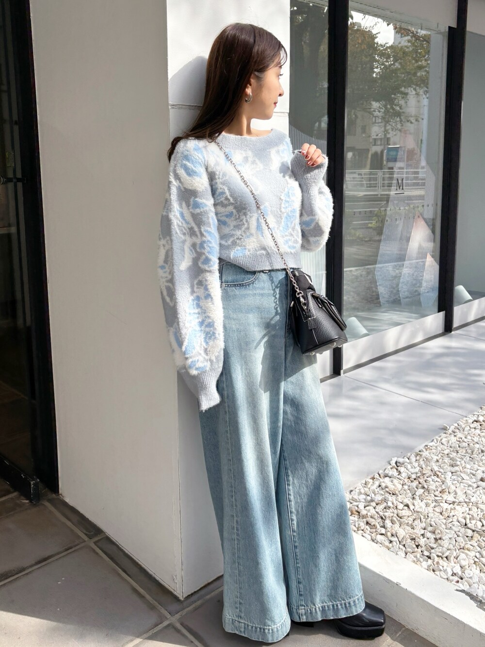 ブルー系のデニムパンツ、ブラック系のブーツ、ブルー系のニット/セーターを着用したレディースの冬コーディネートの4枚目の写真