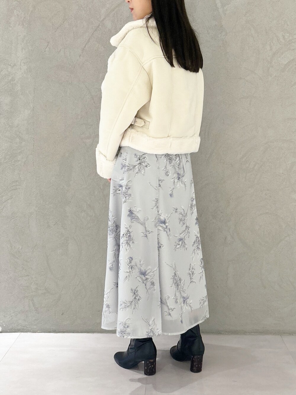 パープル系のワンピース、ブラック系のブーツ、ホワイト系のショルダーバッグを着用したレディースの秋コーディネートの3枚目の写真