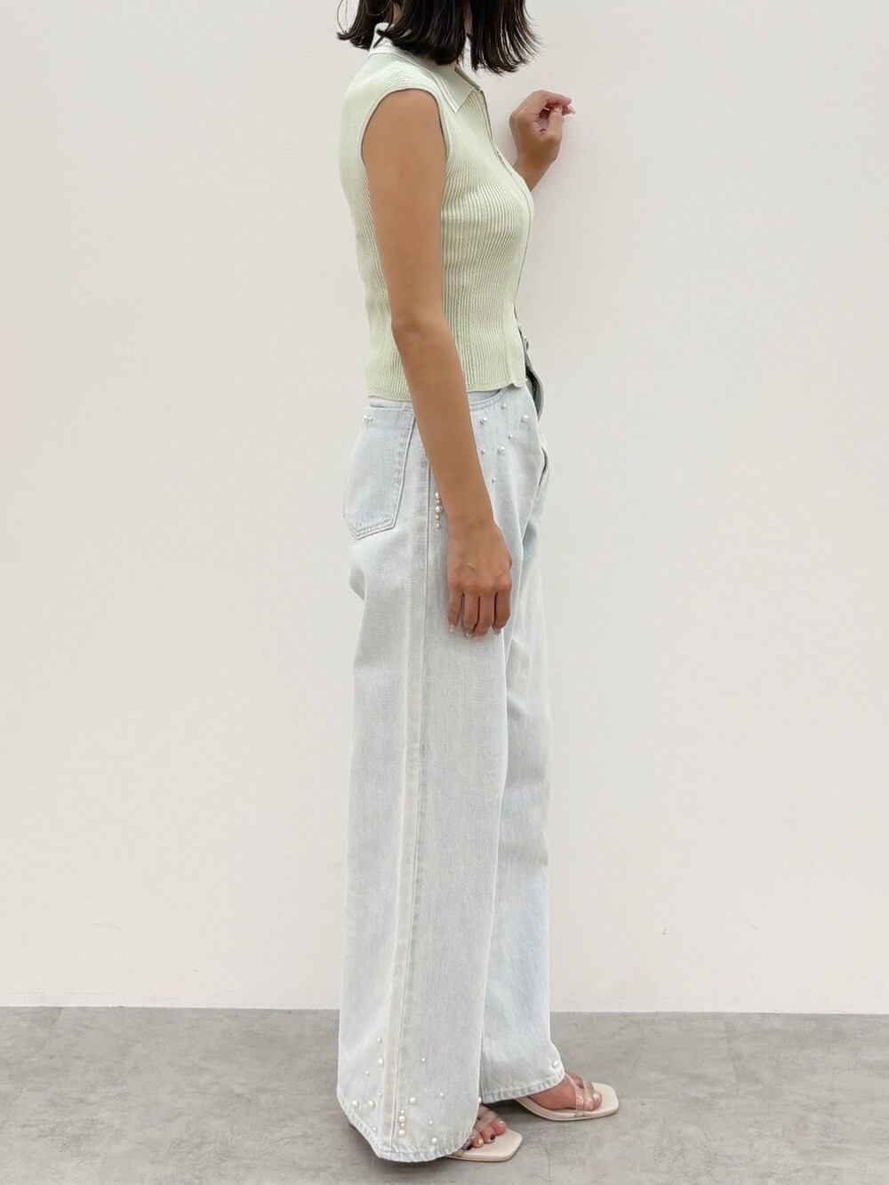 ブルー系のデニムパンツ、グリーン系のニット/セーターを着用したレディースの夏コーディネートの5枚目の写真