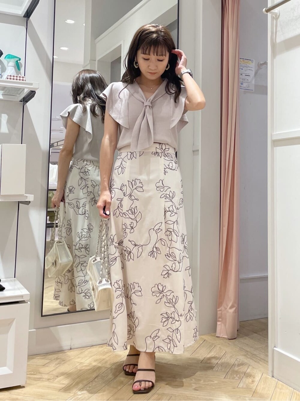 イエロー系のニット/セーター、ホワイト系のスカート、シルバー系のピアス（両耳用）を着用したレディースの夏コーディネートの3枚目の写真