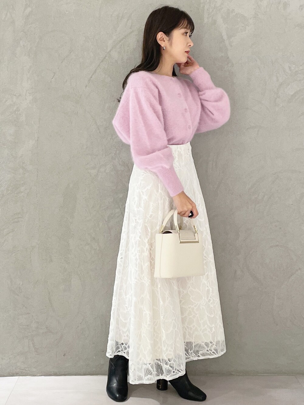 ホワイト系のハンドバッグ、ブラック系のブーツ、ホワイト系のスカートを着用したレディースの秋コーディネートの4枚目の写真