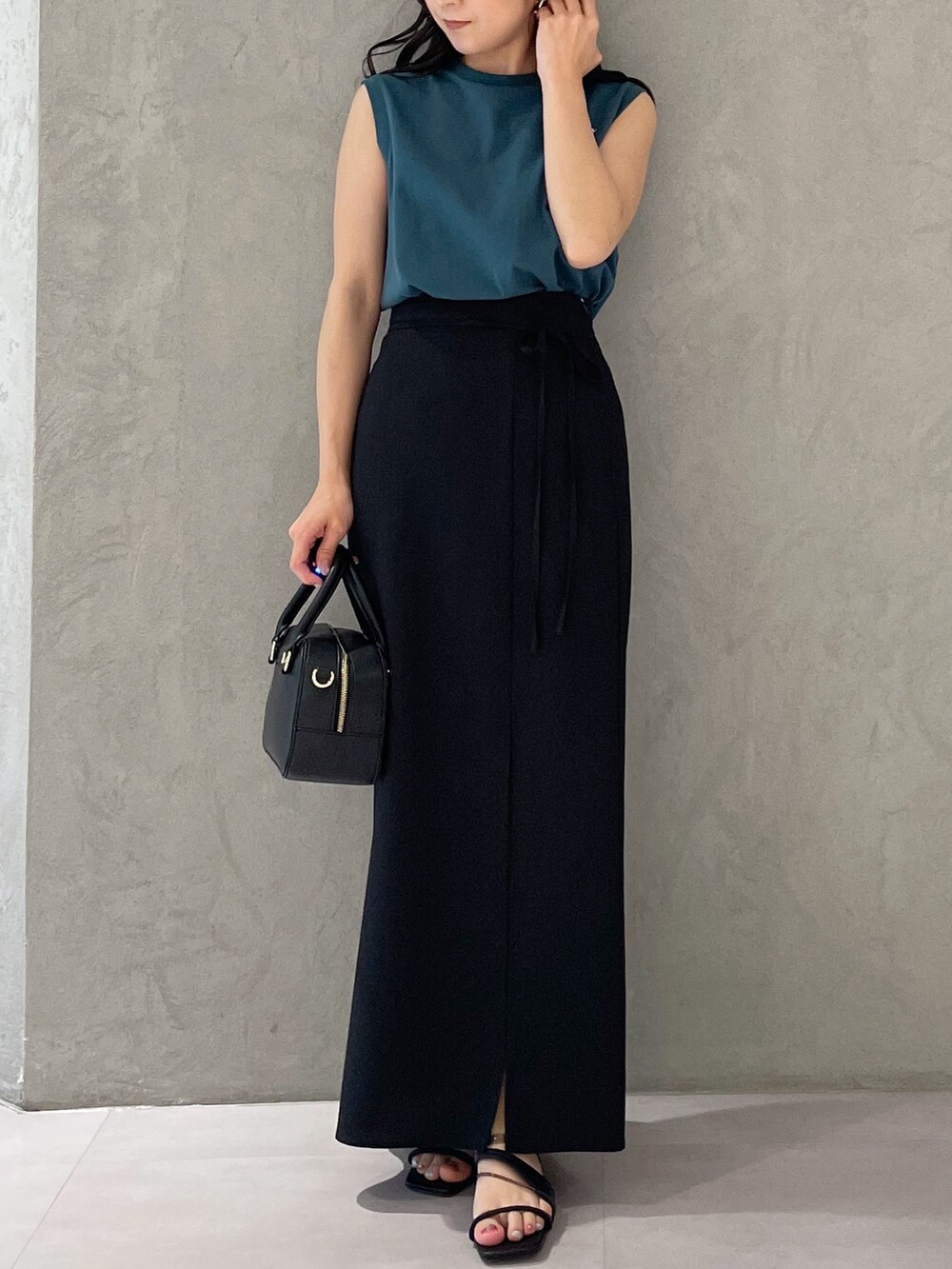 ブラック系のスカート、ブラック系のサンダル、ブラック系のボストンバッグを着用したレディースの春コーディネートの6枚目の写真