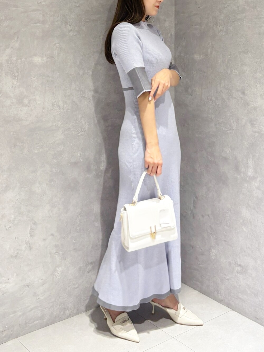 ブルー系のワンピース、ホワイト系のパンプス、ホワイト系のハンドバッグを着用したレディースの春コーディネートの6枚目の写真