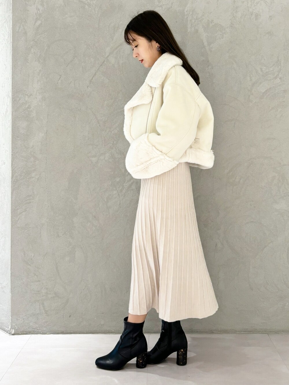 ホワイト系のワンピース、ブラック系のブーツ、ホワイト系のハンドバッグを着用したレディースの秋コーディネートの9枚目の写真