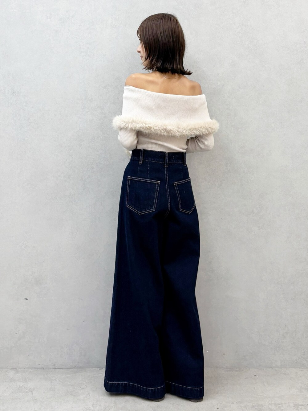 ブルー系のデニムパンツ、ブラウン系のブーツ、ベージュ系のニット/セーターを着用したレディースの秋コーディネートの3枚目の写真