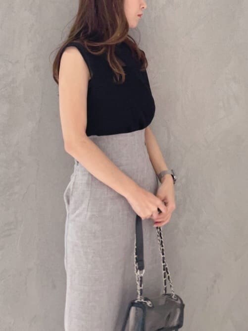 ブラック系のショルダーバッグ、ブラック系のニット/セーター、ブラウン系のサンダルを着用したレディースの夏コーディネートの4枚目の写真