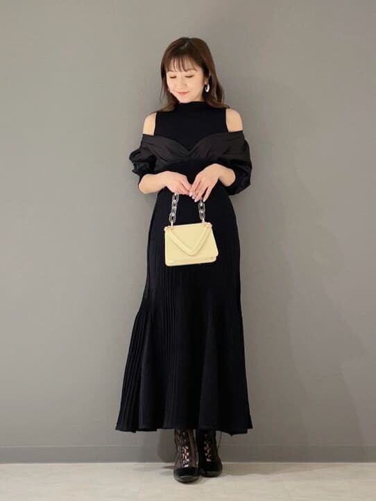 ブラック系のその他シューズ、ブラック系のワンピース、イエロー系のショルダーバッグを着用したレディースの冬コーディネートの3枚目の写真
