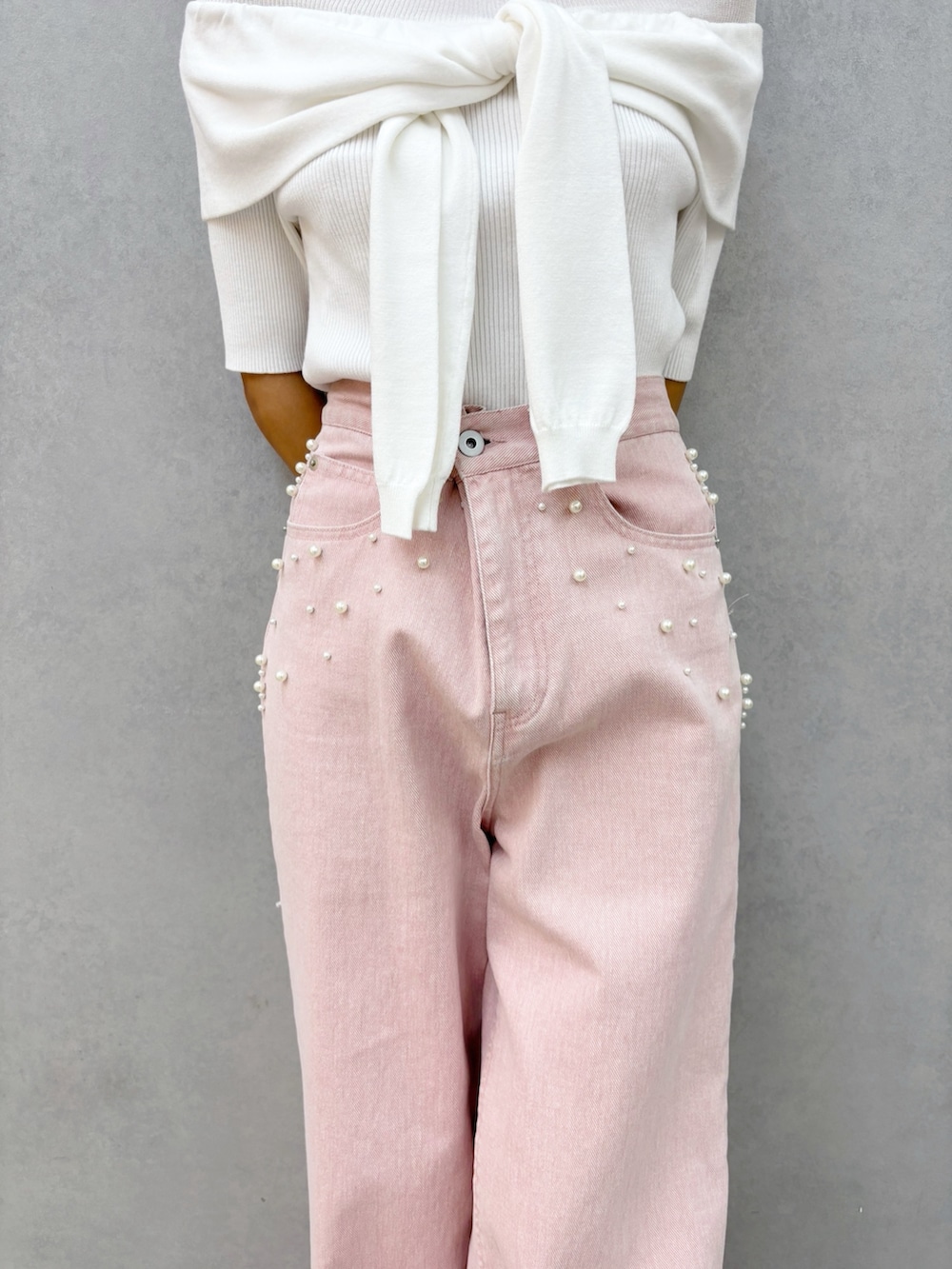 ピンク系のデニムパンツ、その他のサンダル、ホワイト系のニット/セーターを着用したレディースの春コーディネートの4枚目の写真