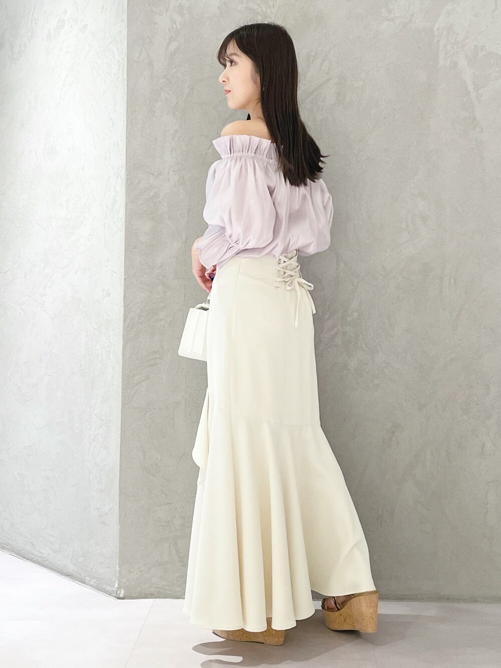 ホワイト系のスカート、ホワイト系のショルダーバッグ、ブラウン系のサンダルを着用したレディースの春コーディネートの4枚目の写真