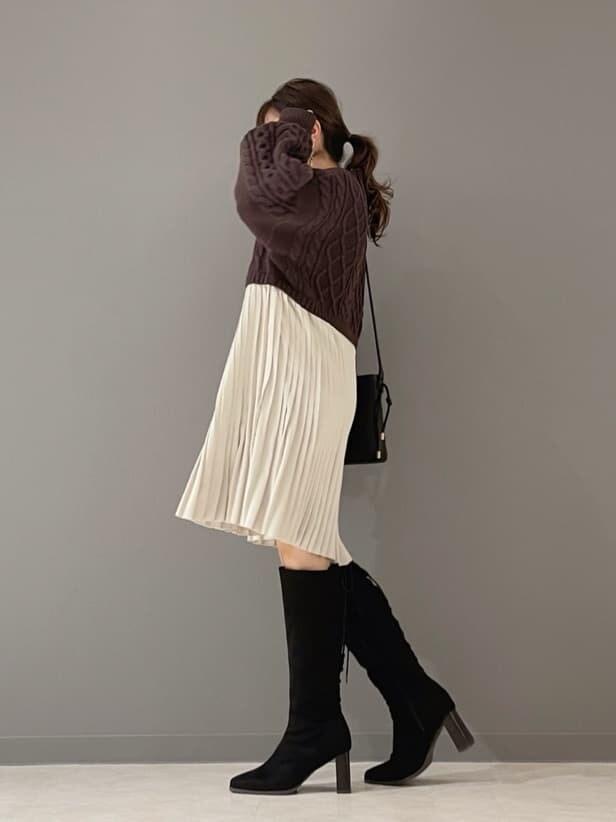 ベージュ系のショルダーバッグ、ブラウン系のワンピース、ゴールド系のピアス（両耳用）を着用したレディースの冬コーディネートの5枚目の写真