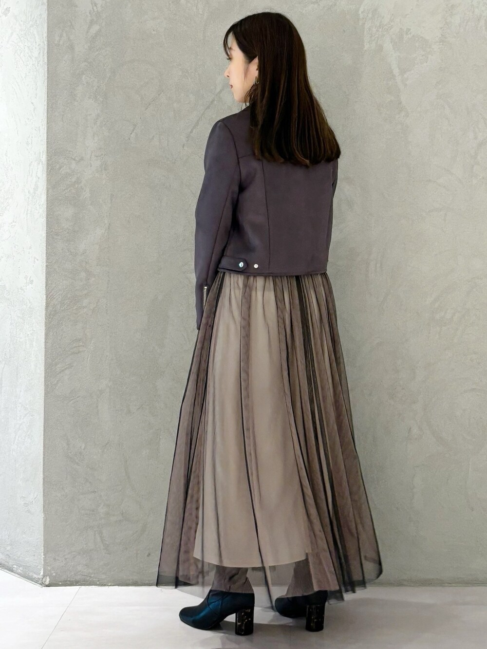 ブラック系のワンピース、ブラック系のブーツ、ブラウン系のハンドバッグを着用したレディースの秋コーディネートの3枚目の写真