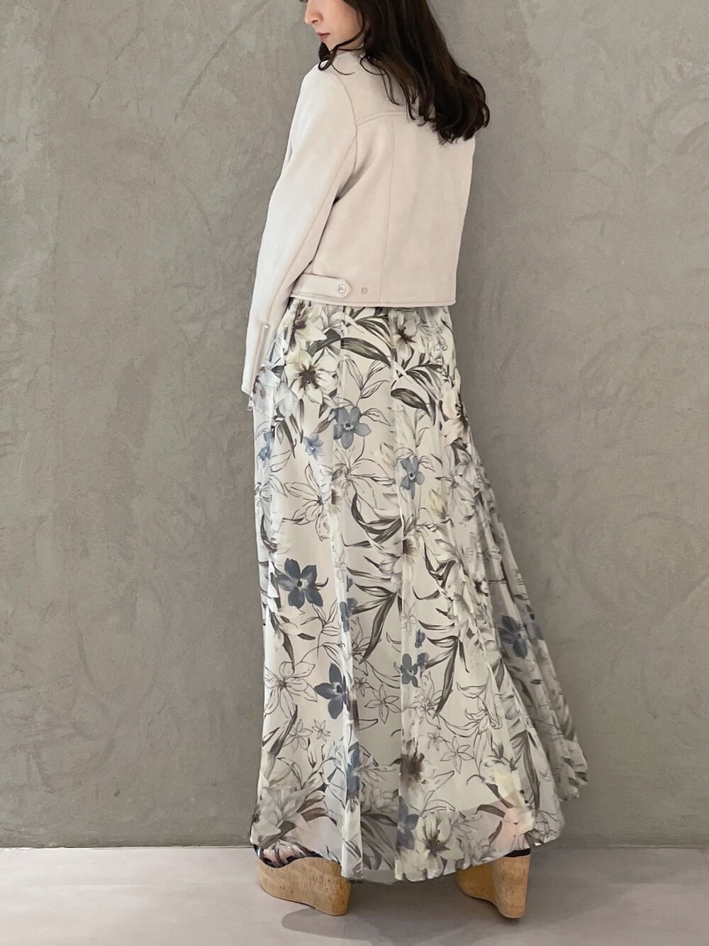 グリーン系のスカート、ピンク系のライダースジャケット、ブラック系のサンダルを着用したレディースの春コーディネートの6枚目の写真