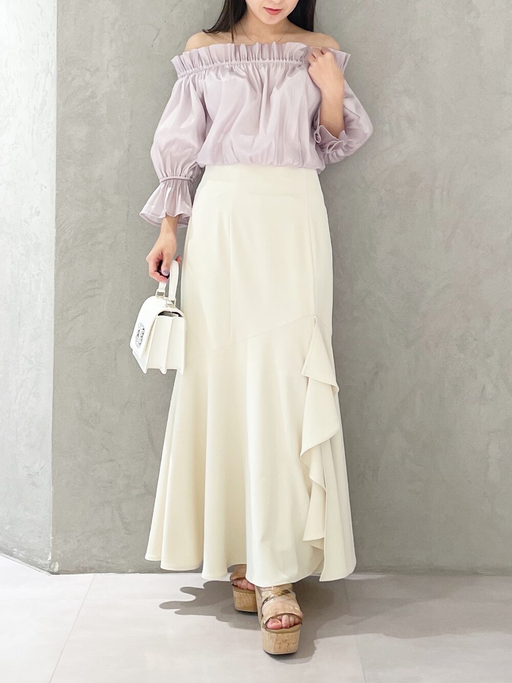 ホワイト系のスカート、ホワイト系のショルダーバッグ、ブラウン系のサンダルを着用したレディースの春コーディネートの5枚目の写真