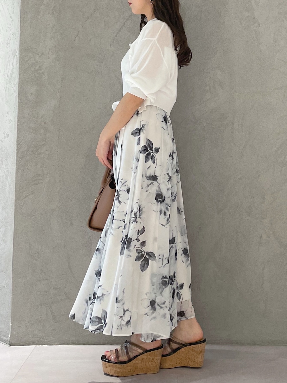 ホワイト系のワンピース、ブラック系のサンダル、ブラウン系のトートバッグを着用したレディースの夏コーディネートの6枚目の写真