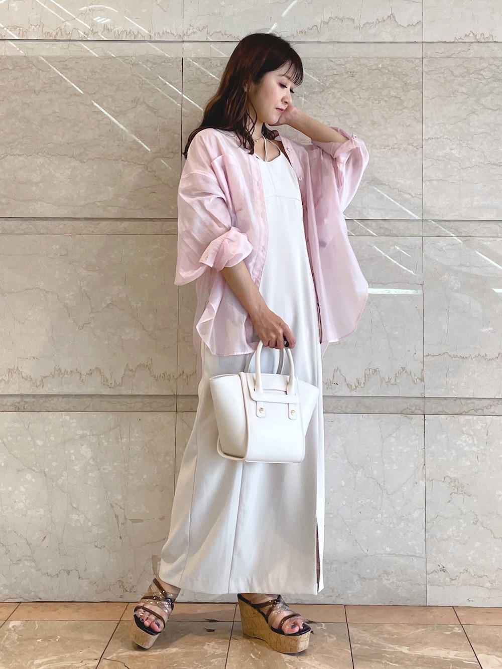 ホワイト系のトートバッグ、ブラック系のサンダル、ベージュ系のワンピースを着用したレディースの夏コーディネートの2枚目の写真