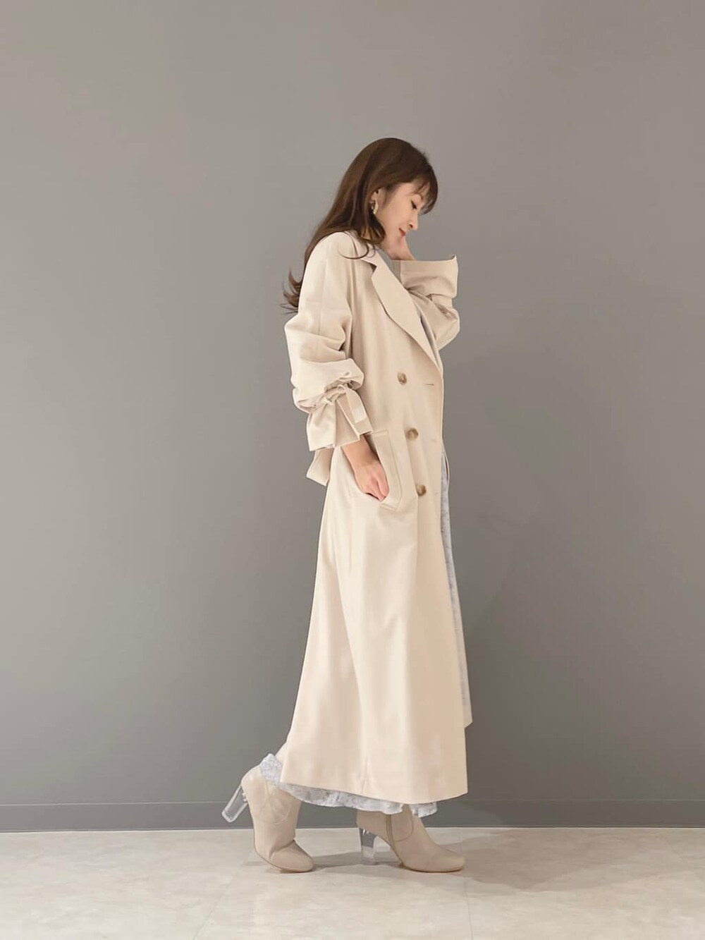 ベージュ系のその他シューズ、ベージュ系のトレンチコート、ブルー系のワンピースを着用したレディースの冬コーディネートの4枚目の写真