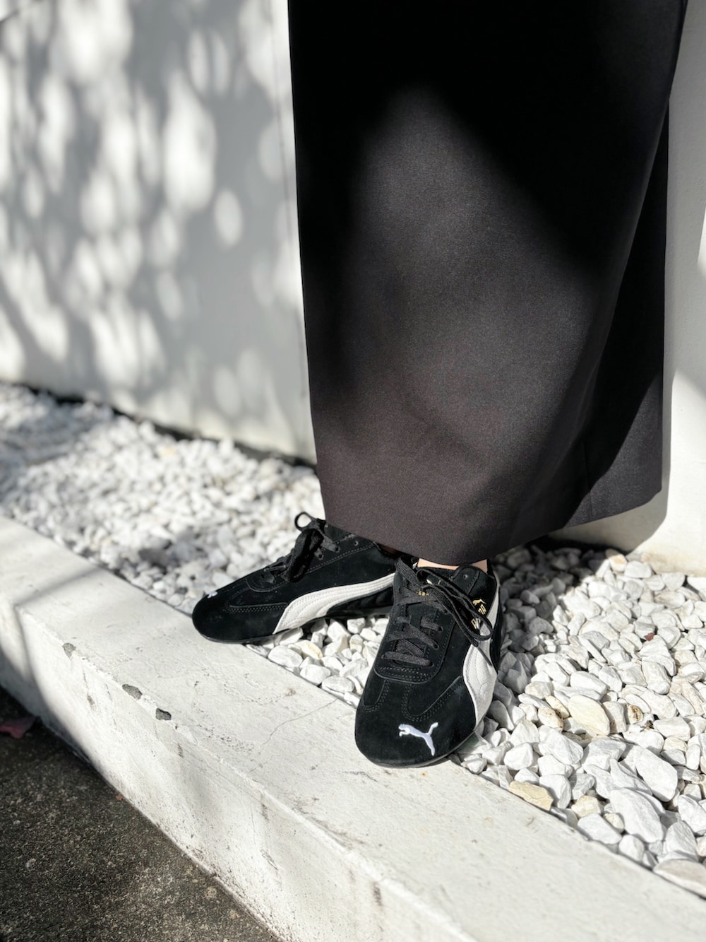 ブラック系のスカート、ブラック系のスニーカー、グレー系のニット/セーターを着用したレディースの秋コーディネートの6枚目の写真