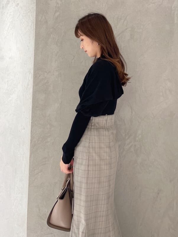 ブラウン系のハンドバッグ、グレー系のスカート、ブラック系のニット/セーターを着用したレディースの秋コーディネートの3枚目の写真