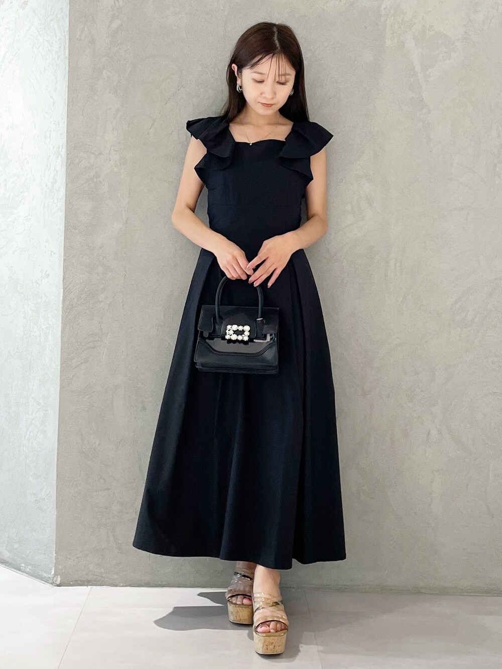 ブラック系のワンピース、ブラウン系のサンダル、ブラック系のショルダーバッグを着用したレディースの夏コーディネートの5枚目の写真